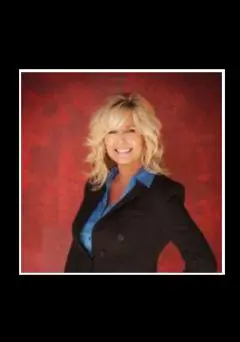 A woman in black jacket standing next to red wall.